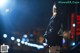 A woman standing in the middle of a city at night.