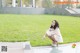 A woman sitting on the ground in a park.