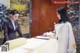 A woman signing a document at a reception desk.