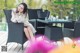 A woman sitting at a table with a cup of coffee.