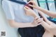 A woman in a sailor outfit is putting on a tie.