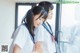 Two young women in school uniforms standing next to each other.