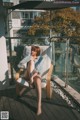 A woman sitting in a chair on a balcony.