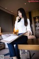 A woman sitting on a table holding a book.