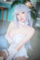 A woman with long blue hair wearing a white dress and gloves.