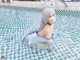 A woman in a blue and white dress sitting in a pool.