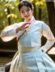 A woman in a white hanbok is posing for a picture.