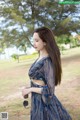 A woman in a blue dress standing in a field.