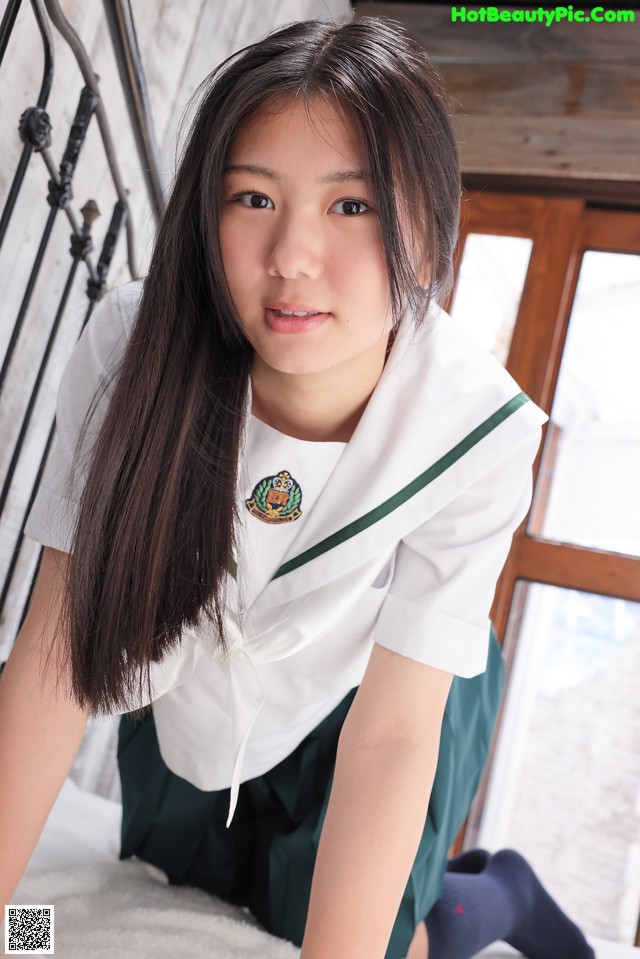 A young woman in a school uniform posing for a picture.