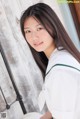 A young woman in a white shirt and green skirt.