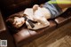 A woman laying on top of a brown couch.