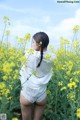 A woman standing in a field of yellow flowers.