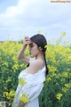 A woman in a field of yellow flowers.