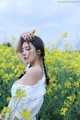 A woman in a field of yellow flowers.