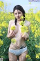 A woman in a white bikini standing in a field of yellow flowers.