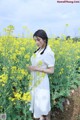 A woman standing in a field of yellow flowers.