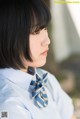 A woman in a blue shirt and a striped tie.