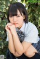 A young woman in a school uniform posing for a picture.