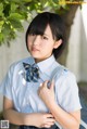 A young woman in a school uniform with a backpack.