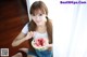 A woman sitting on the floor eating a slice of watermelon.