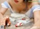 A woman in a blue and white dress is making a cake.