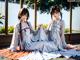 A couple of women sitting on top of a wooden floor.