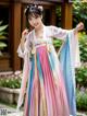 A woman in a pink and blue hanfu dress posing for a picture.