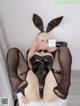 A woman in a bunny costume is sitting on a toilet.