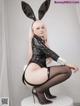 A woman in a bunny costume sitting on a stool.