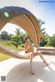 A woman sitting in a hammock on a patio.