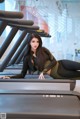 A woman laying on a treadmill in a gym.