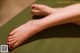 A woman's feet with red nail polish on a green mat.