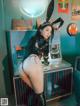 A woman in a bunny costume posing in front of a jukebox.