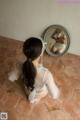 A woman sitting on the floor in front of a mirror.