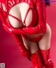 A woman in a red latex outfit and boots.