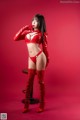 A woman in a red latex outfit posing for a picture.