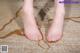 A pair of bare feet on a carpeted floor.