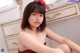 A woman in a red and black lingerie sitting on a dresser.