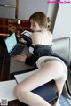 A woman sitting at a desk with a laptop computer.