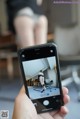 A person taking a picture of a woman sitting on a chair.