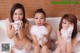 A group of three young women in a bathtub covered in foam.