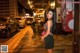 A woman standing in the middle of a city street at night.